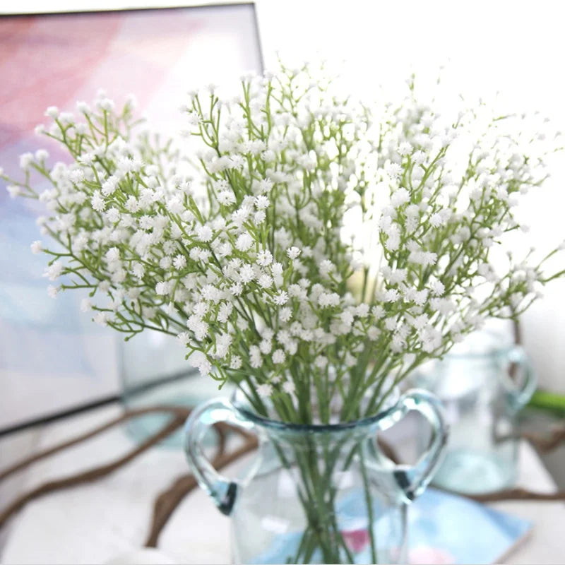Main product photo  
Rustic wicker basket filled with white baby’s breath flowers on wooden bench

Close-up of flowers  
Delicate baby’s breath blossoms with tiny white clusters and green stems

Top-down arrangement shot  
Handwoven wicker basket top view showing full baby’s breath bouquet

Lifestyle scene with book and tea  
Cozy outdoor garden scene with wicker flower basket, open book, and tea cup

Detail of basket weave  
Textured handwoven wicker basket rim and natural fibers

Mixed blooms close-up  
B