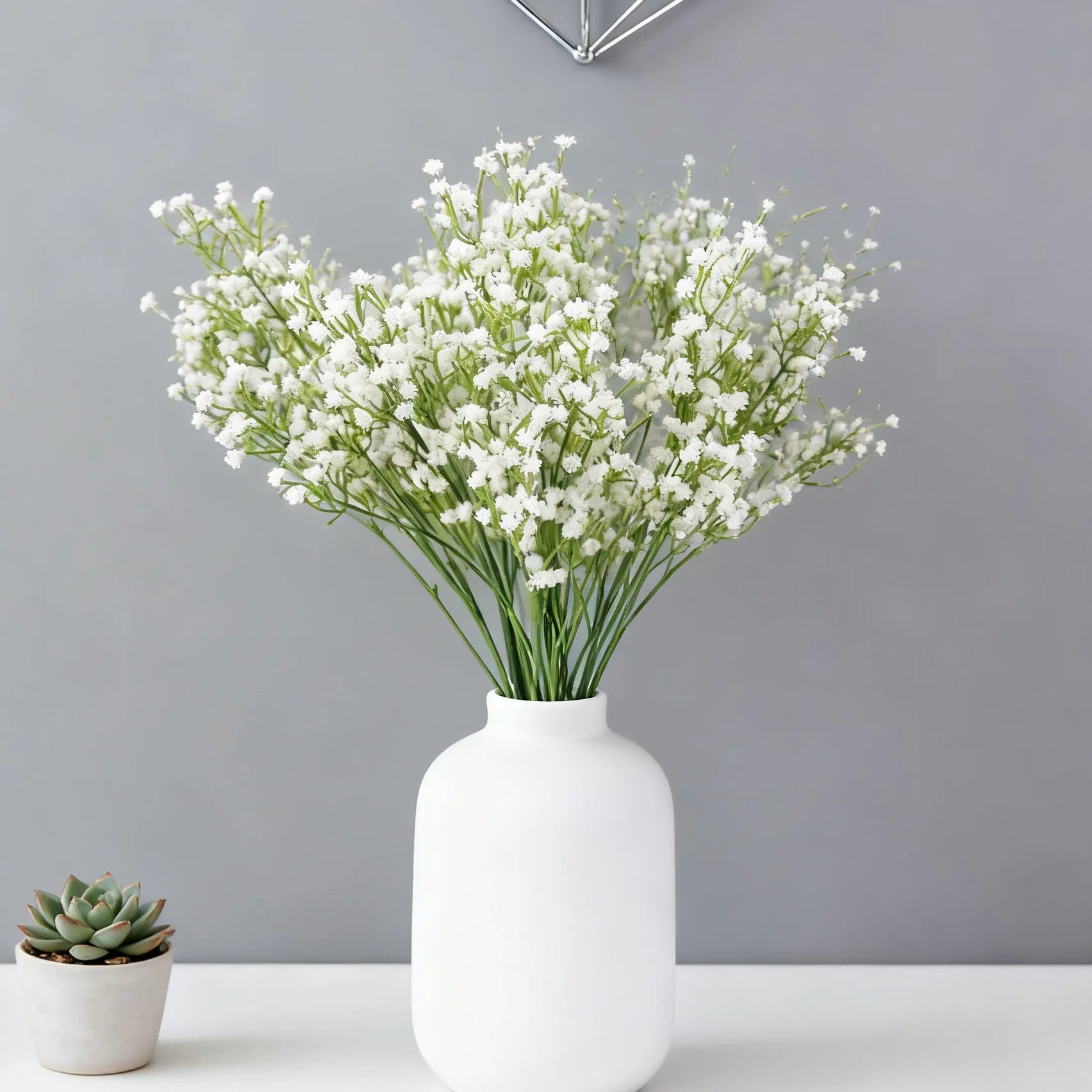 Main product photo — Rustic wicker basket filled with white baby’s breath flowers on wooden bench

Close-up flowers — Delicate baby’s breath blossoms with tiny white clusters and green stems

Top-down arrangement — Handwoven wicker basket top view showing full baby’s breath bouquet

Lifestyle scene with book and tea — Cozy outdoor garden scene with wicker flower basket, open book, and tea cup

Detail of basket weave — Textured handwoven wicker basket rim and natural fibers

Mixed blooms close-up — Baby’s br