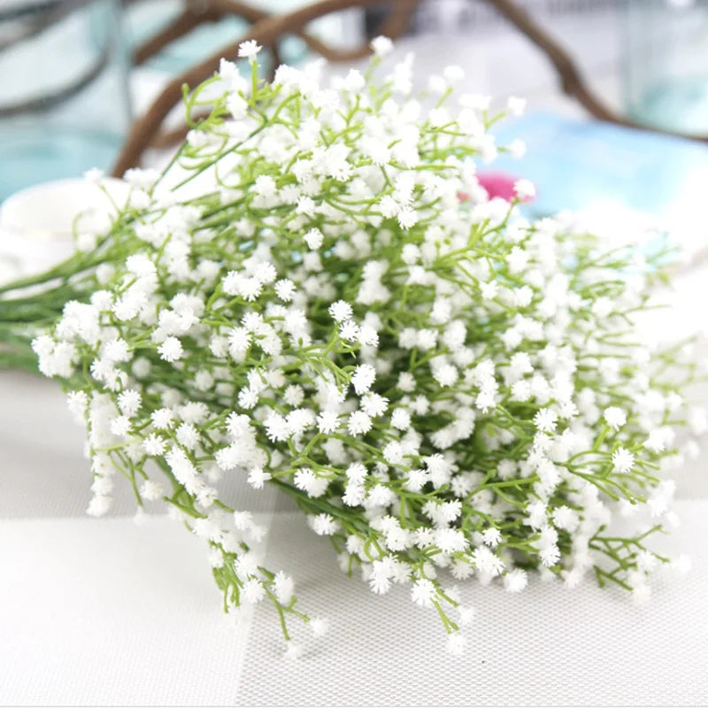 Main product photo — White baby’s breath wicker basket on wooden bench

Close-up flowers — Delicate baby’s breath blossoms with tiny white clusters

Top-down arrangement — Top view of handwoven basket filled with Gypsophila bouquet

Lifestyle scene with book and tea — Cozy garden scene with flower basket, open book, and tea cup

Basket weave detail — Textured handwoven wicker rim and natural fiber weave

Mixed blooms close-up — Baby’s breath with lily of the valley sprigs in basket

Vase display photo — Cle